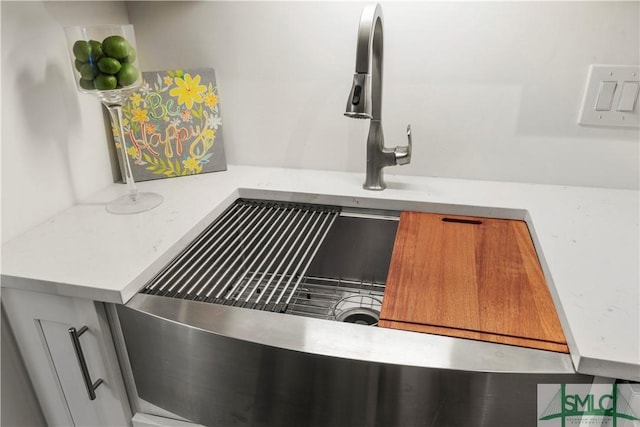 details featuring light stone counters and sink