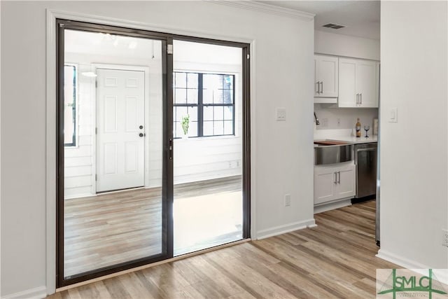 doorway with sink and light hardwood / wood-style flooring