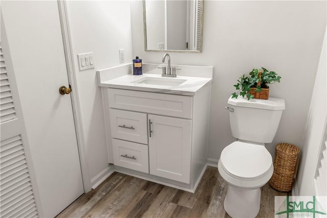 bathroom with vanity, toilet, and wood-type flooring