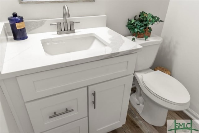 bathroom featuring hardwood / wood-style flooring, vanity, and toilet