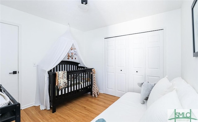 bedroom with a nursery area and hardwood / wood-style floors