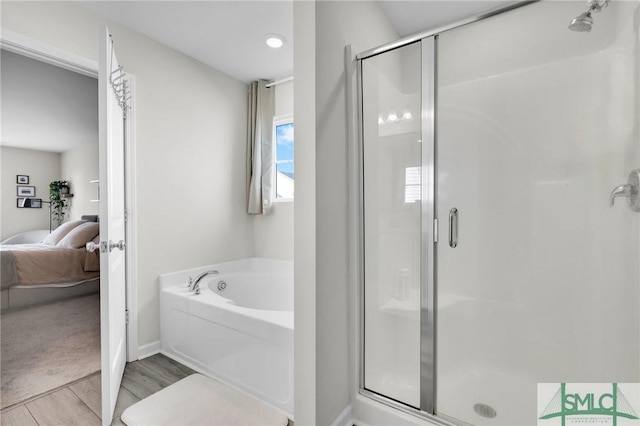 bathroom featuring wood-type flooring and separate shower and tub