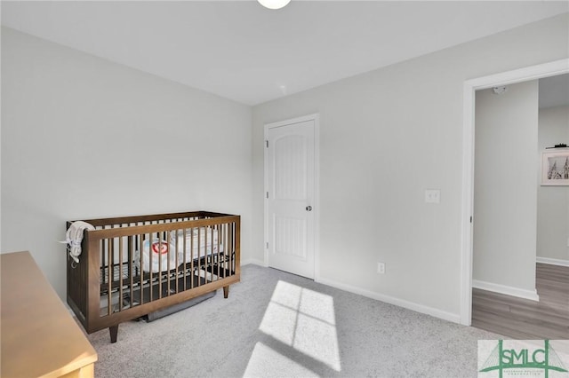 bedroom with a nursery area, carpet floors, and a closet