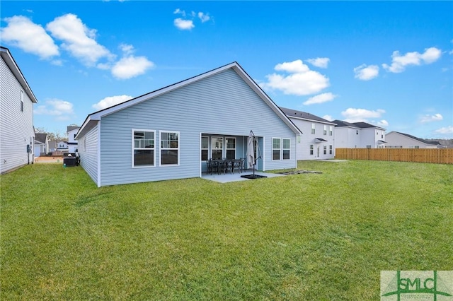 rear view of property featuring a yard and a patio area