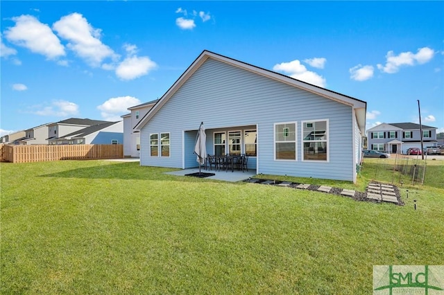 rear view of house with a patio and a lawn