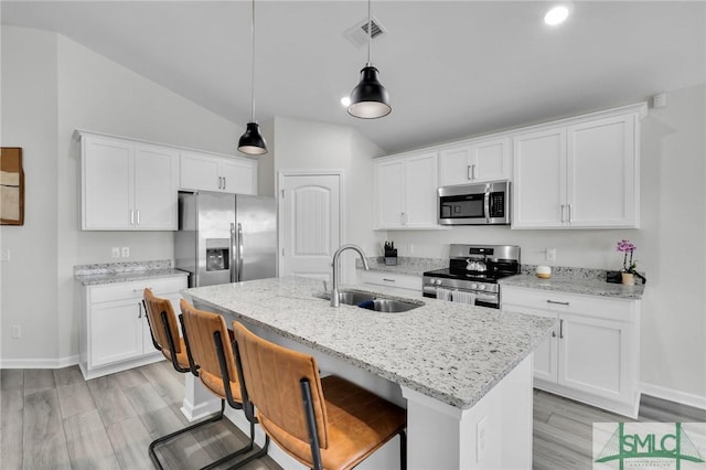 kitchen with stainless steel appliances, white cabinetry, and sink