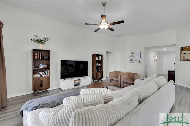 living room with wood-type flooring and ceiling fan