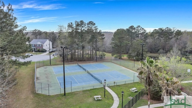 view of sport court featuring a lawn and tennis court