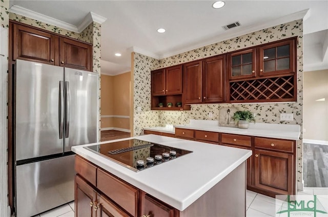 kitchen with a kitchen island, stainless steel fridge, ornamental molding, light tile patterned floors, and black electric cooktop