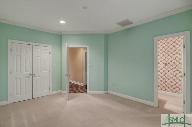 unfurnished bedroom with crown molding, a closet, and carpet flooring