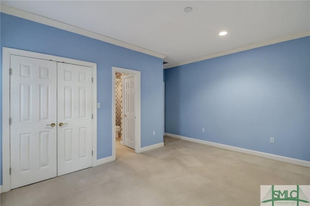 unfurnished bedroom with crown molding, light colored carpet, and a closet