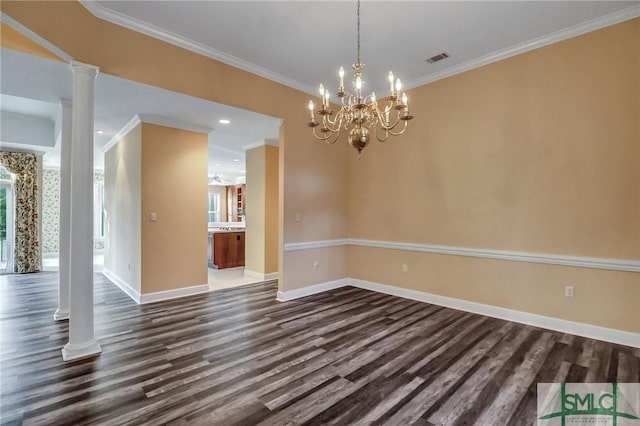 empty room featuring dark wood-type flooring, ornamental molding, an inviting chandelier, and ornate columns