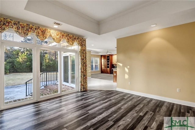 unfurnished room with ornamental molding, wood-type flooring, and a tray ceiling