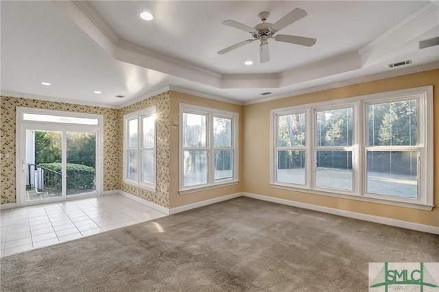 spare room featuring light colored carpet, ornamental molding, and a tray ceiling