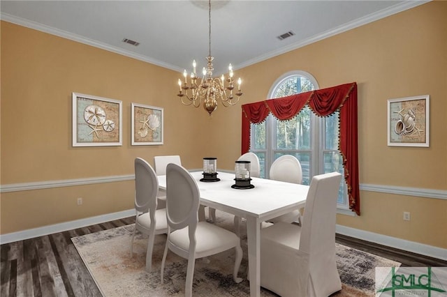 dining space featuring crown molding, a chandelier, and dark hardwood / wood-style flooring