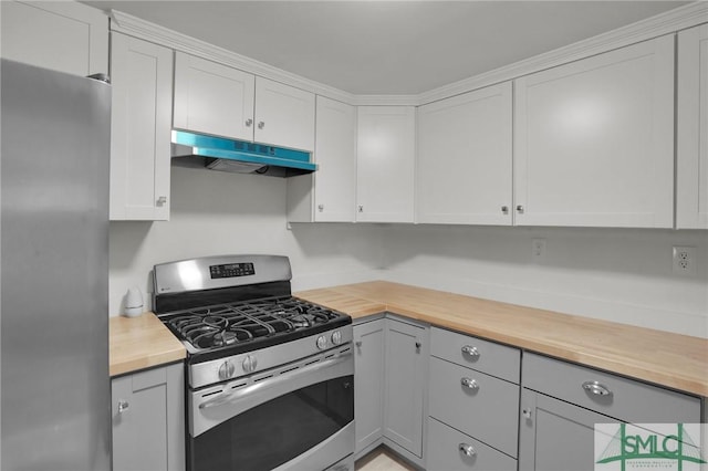 kitchen with appliances with stainless steel finishes, white cabinets, and wood counters