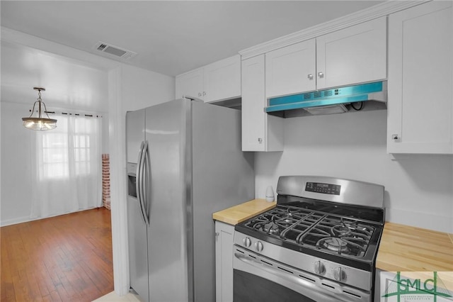 kitchen featuring appliances with stainless steel finishes, white cabinetry, hanging light fixtures, butcher block counters, and light hardwood / wood-style floors