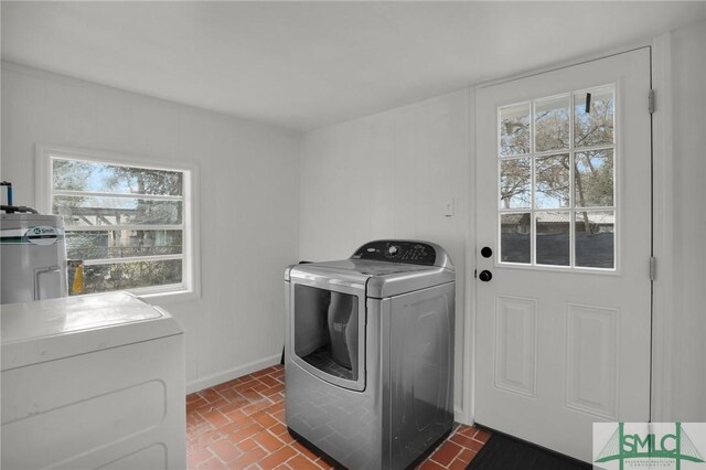 laundry area with washer and clothes dryer and a healthy amount of sunlight