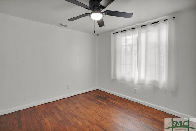 empty room with dark hardwood / wood-style floors and ceiling fan