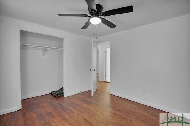 unfurnished bedroom featuring ceiling fan, dark hardwood / wood-style flooring, and a closet