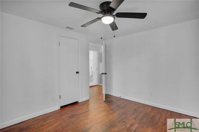 empty room featuring dark wood-type flooring and ceiling fan