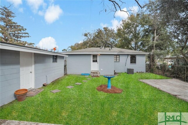 back of house with central AC and a lawn