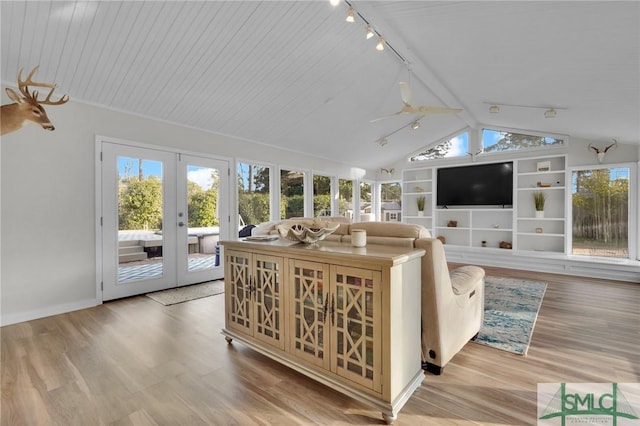 living room featuring plenty of natural light, wood-type flooring, and vaulted ceiling with beams