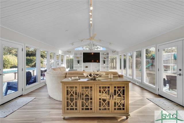 sunroom featuring lofted ceiling and plenty of natural light