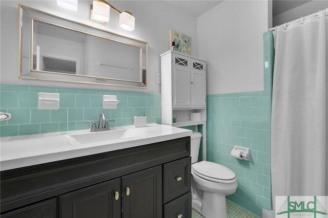 bathroom with tile walls, tile patterned flooring, vanity, curtained shower, and toilet