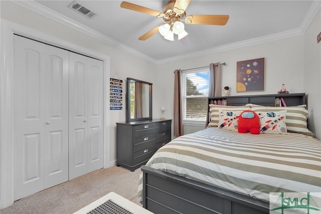 carpeted bedroom with crown molding, ceiling fan, and a closet