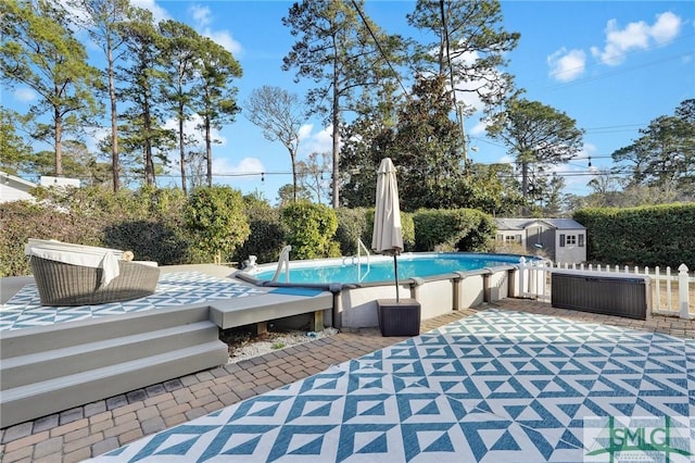 view of swimming pool featuring a storage shed and a patio