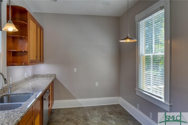 kitchen featuring light stone counters, decorative light fixtures, dishwasher, and sink