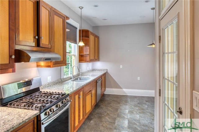 kitchen featuring sink, range hood, hanging light fixtures, appliances with stainless steel finishes, and light stone countertops