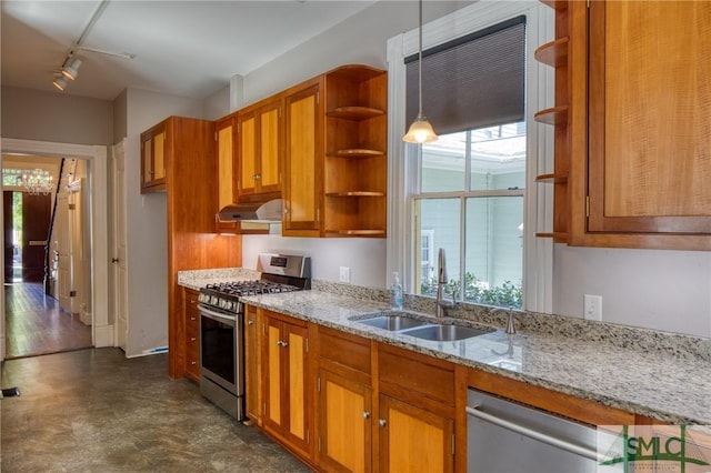 kitchen featuring pendant lighting, sink, appliances with stainless steel finishes, light stone counters, and track lighting