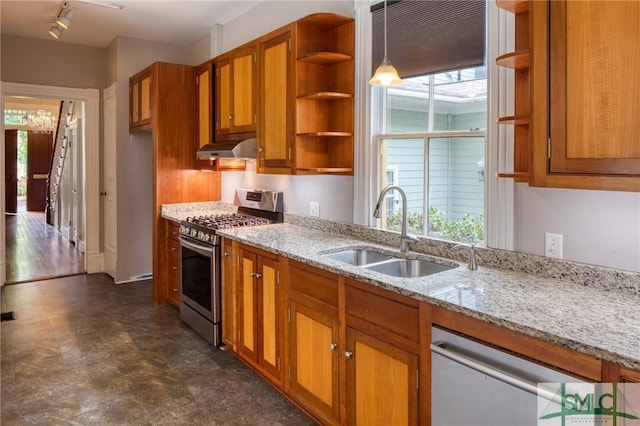 kitchen featuring decorative light fixtures, rail lighting, sink, light stone counters, and gas stove