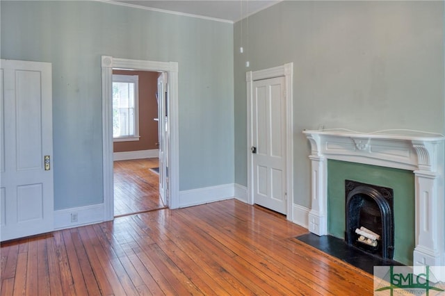 unfurnished living room with hardwood / wood-style flooring and ornamental molding