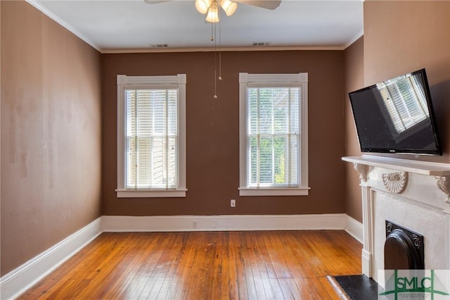 unfurnished living room featuring wood-type flooring, ceiling fan, and crown molding