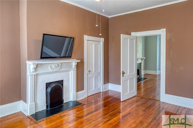 unfurnished living room with hardwood / wood-style floors and crown molding