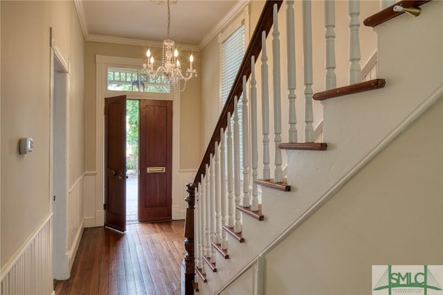 entryway with crown molding, dark hardwood / wood-style floors, and a notable chandelier