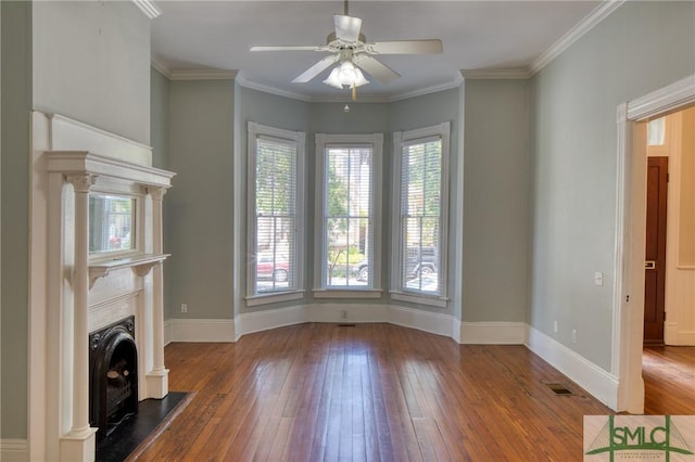 unfurnished living room with hardwood / wood-style flooring, ornamental molding, and ceiling fan