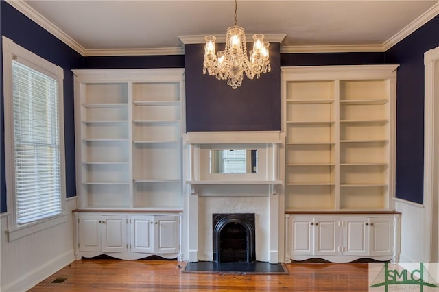 unfurnished living room featuring dark wood-type flooring, ornamental molding, and a chandelier