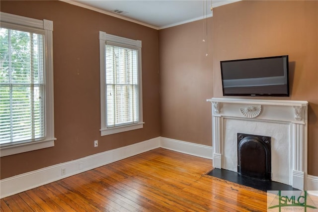 unfurnished living room with ornamental molding, light hardwood / wood-style floors, and a healthy amount of sunlight