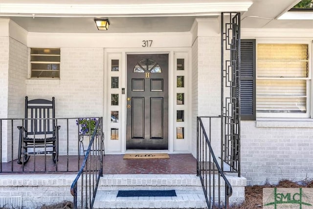 entrance to property featuring brick siding