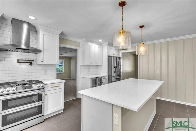 kitchen featuring stainless steel appliances, white cabinetry, a center island, and wall chimney exhaust hood