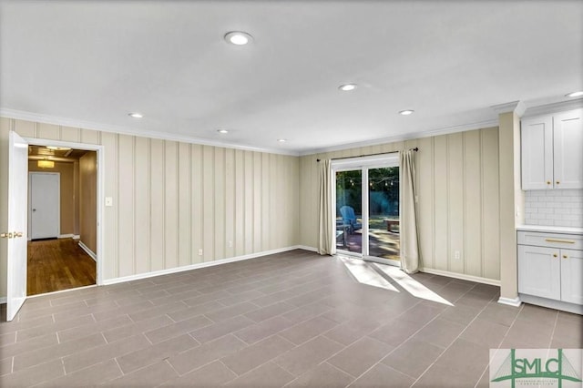 unfurnished living room featuring crown molding