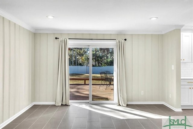 doorway featuring dark tile patterned flooring and crown molding