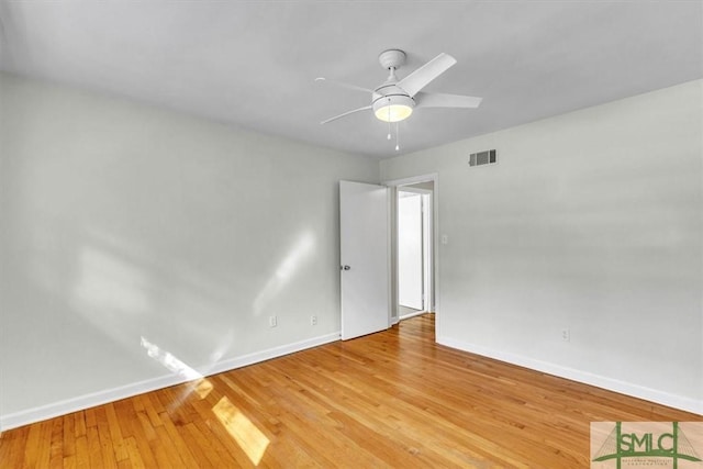 empty room featuring light wood-style floors, baseboards, visible vents, and ceiling fan