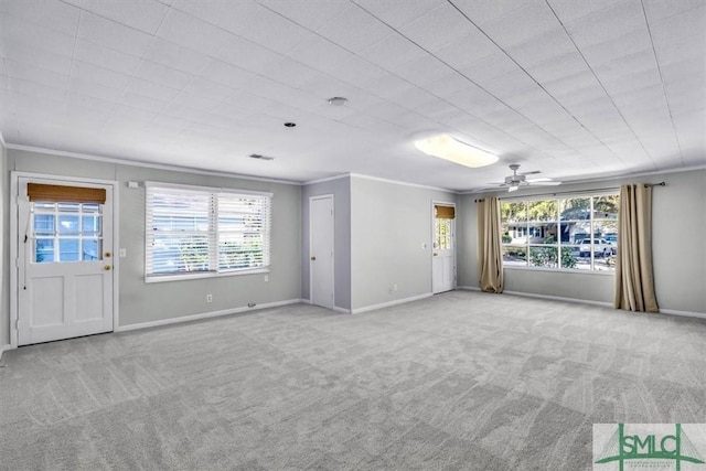 unfurnished living room featuring light carpet, plenty of natural light, and ornamental molding