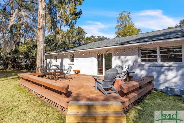 wooden terrace featuring a yard and outdoor dining space