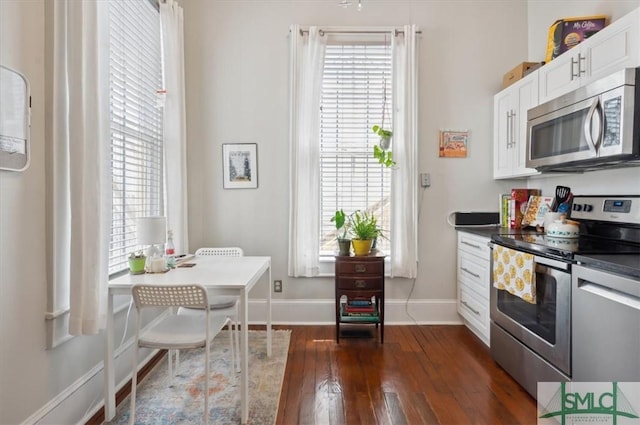 kitchen with plenty of natural light, appliances with stainless steel finishes, and white cabinets